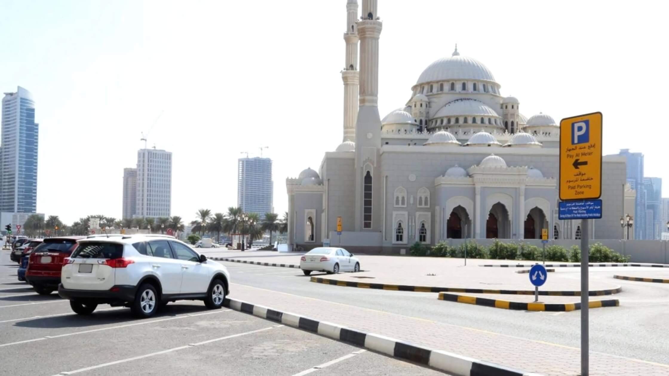 Sharjah UAE National Day 2024 free parking announcement with cityscape in the background.